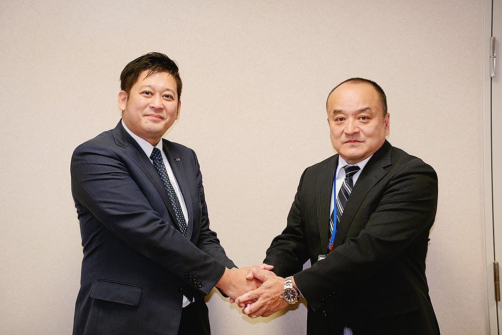 握手を交わす上野社長(左)と河野校長