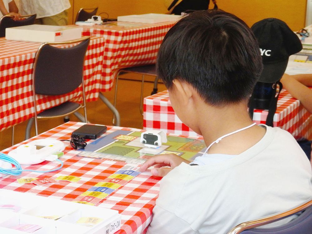 試行錯誤してプログラミング体験に取り組む子供たち
