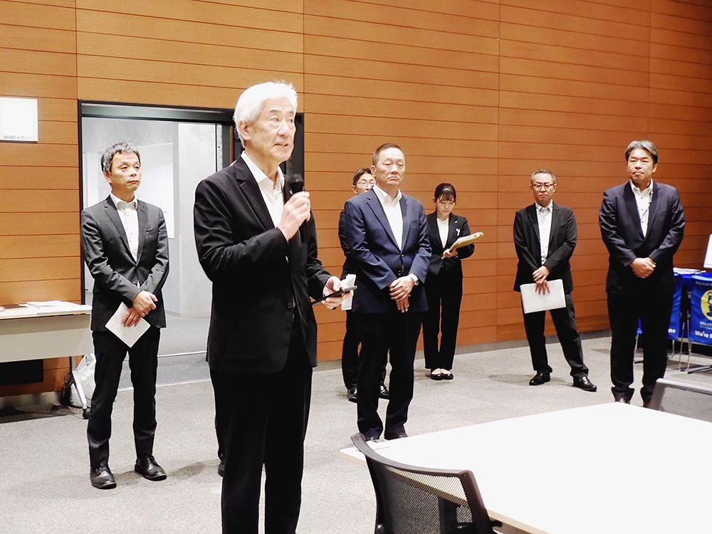 開場前に出展者へ向けあいさつする鴻池会長