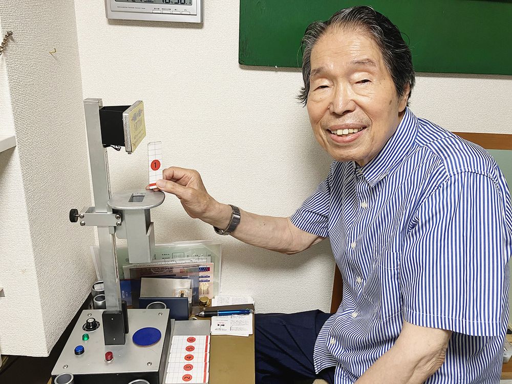 神経反応時間を測定する独自の装置（左）を開発した三浦代表