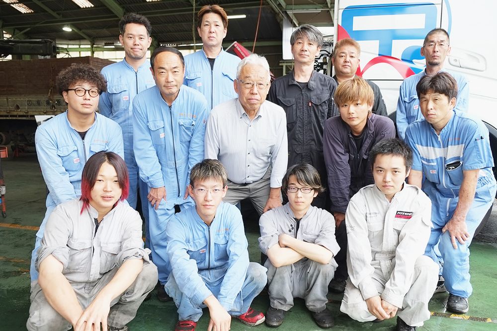 社員と山本社長（中央）