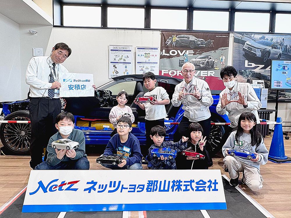 水素の学習体験を終え、講師らと笑顔をみせる子どもたち