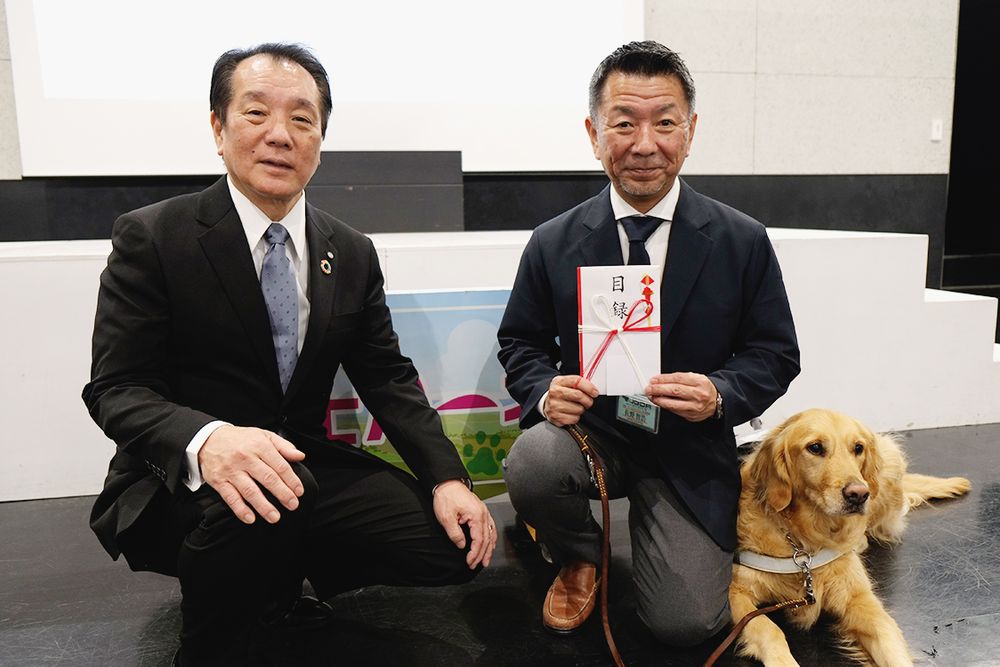 盲導犬訓練施設に対する寄付・支援活動にも注力。寄付金贈呈式で目録を手渡した堀社長(左)