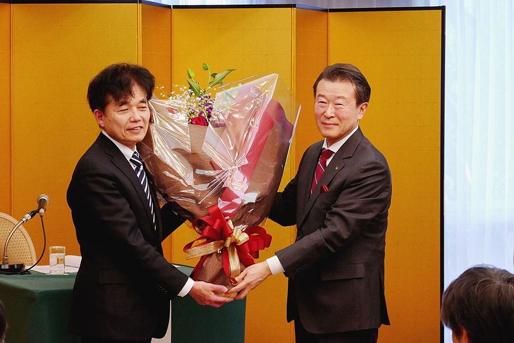 新会長に就任した漆間氏（左）と退任した久保氏
