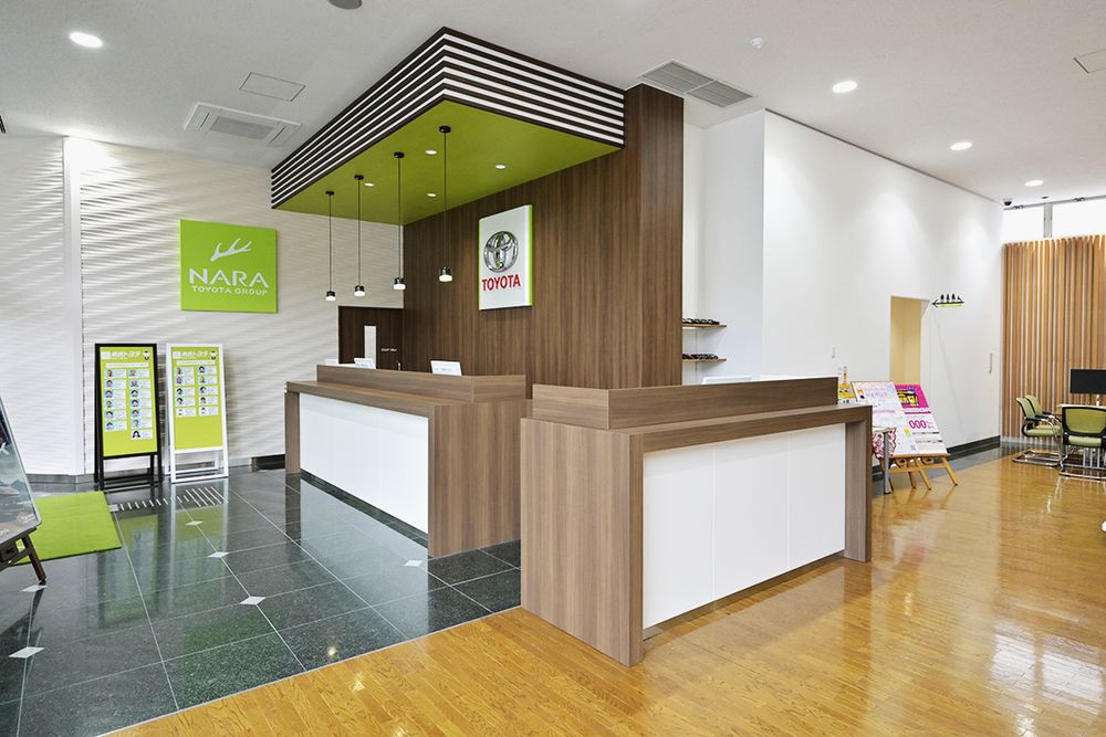 コーポレートカラーの若草色を差し色に加えた受付カウンター
