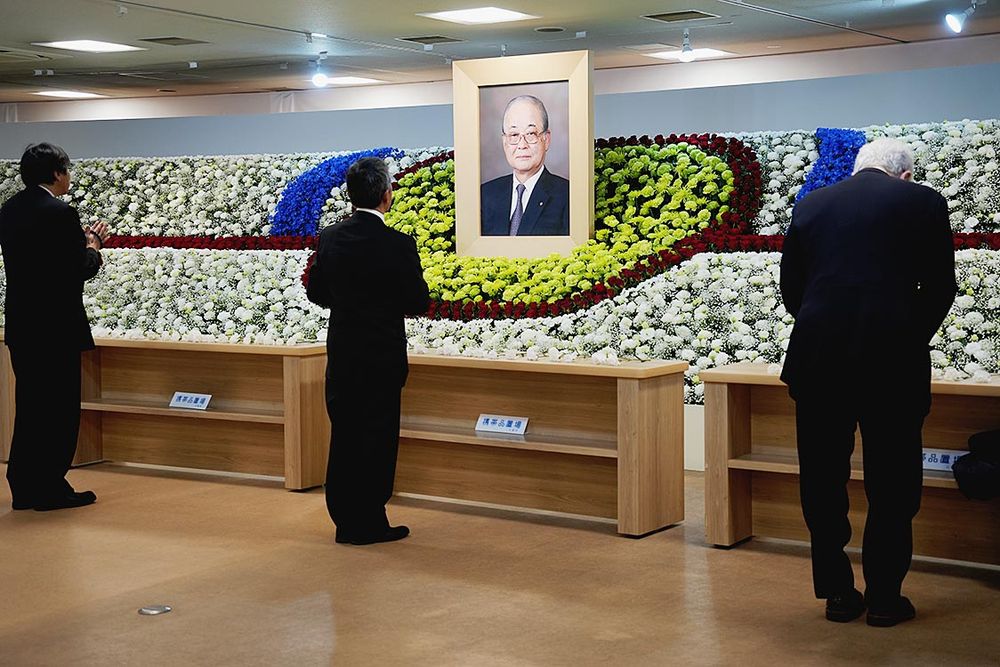 祭壇に献花する参列者ら