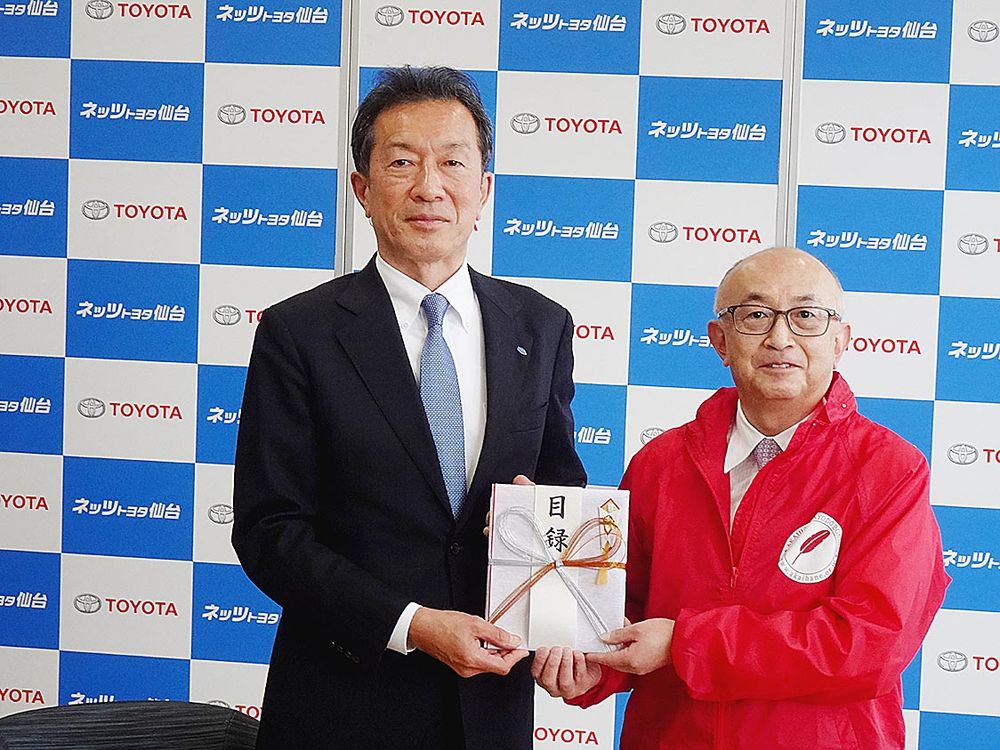 佐々木会長（右）に目録を手渡す三浦社長