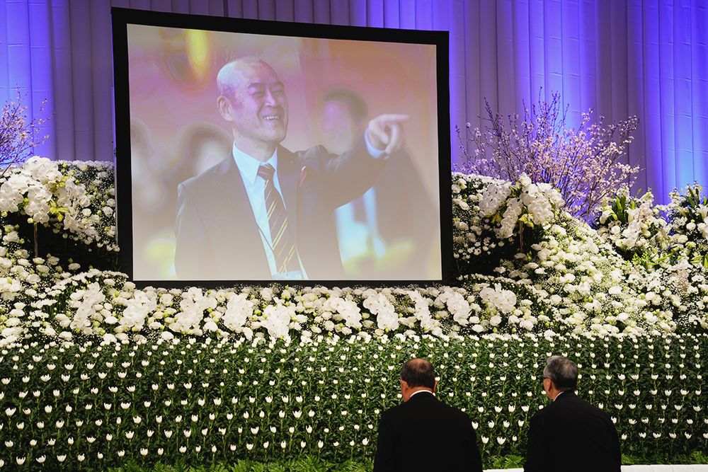 祭壇に献花する参列者ら