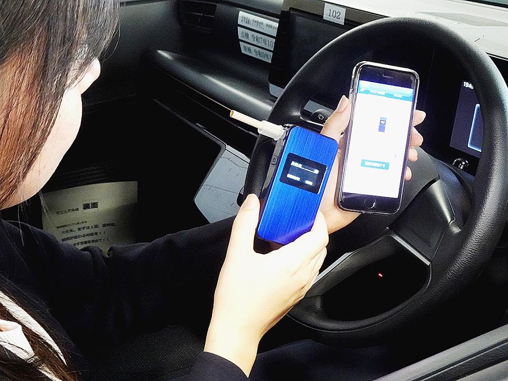 機械（左）でアルコールを検知すれば、画面上に車両の始動が不可能になることを通知する
