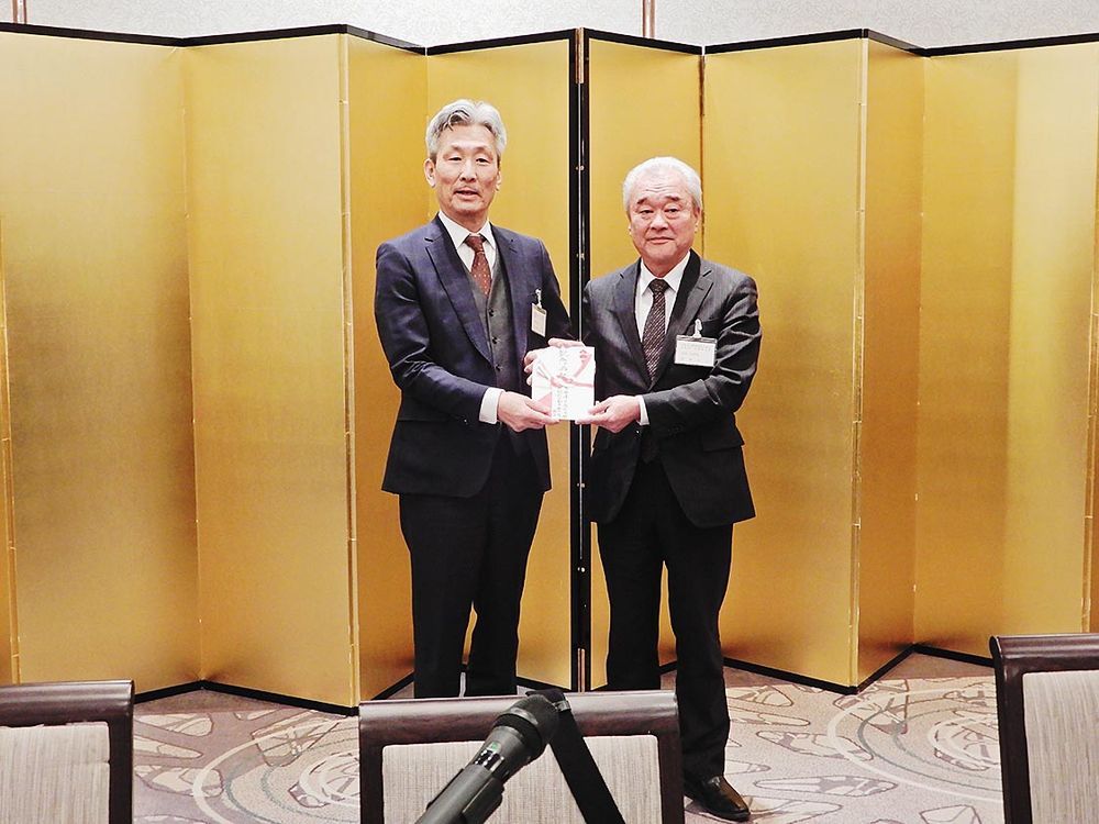 退任する澤井会長・支部長（左）へ記念品を贈呈する伴仲新会長・支部長