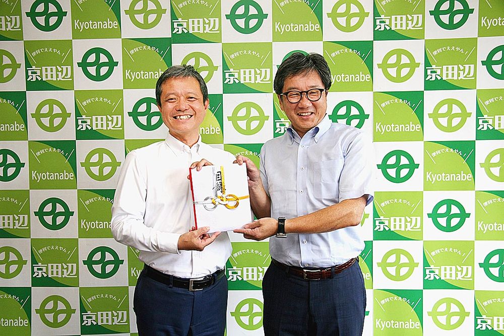 京田辺市での寄付贈呈式。上村崇市長（左）と森松倫取締役