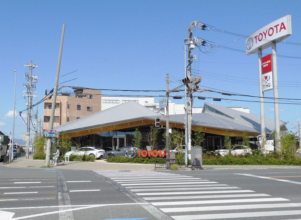 交差点道路側にトヨタのロゴをアピールするトヨタモビリティ新大阪の寝屋川店